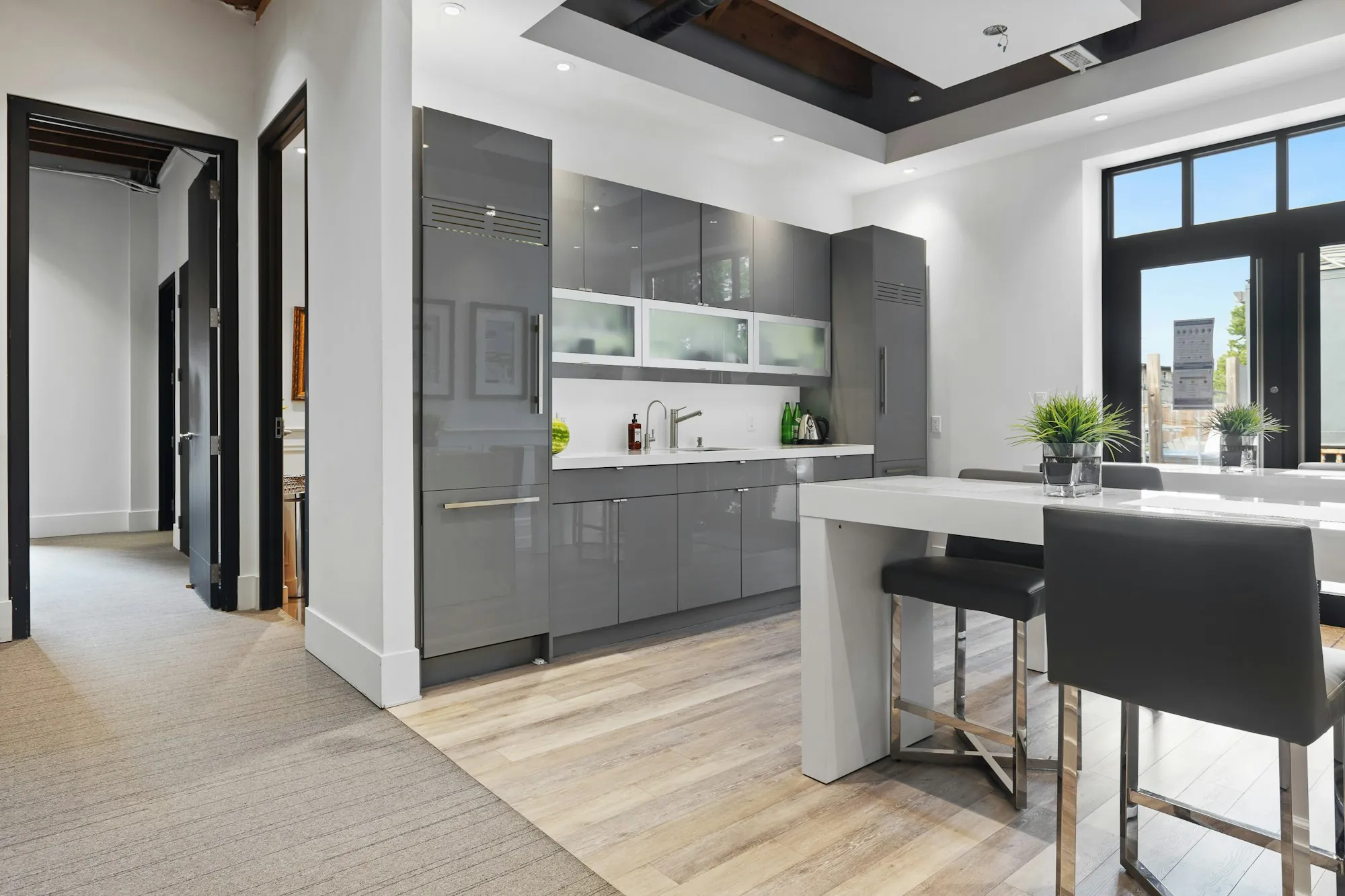 Office kitchen with gray cabinets and stools